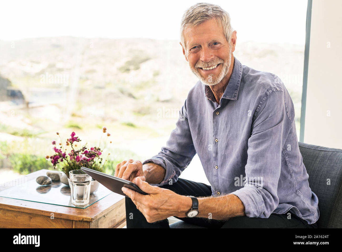 Portrait of smiling senior woman using tablet at home Banque D'Images