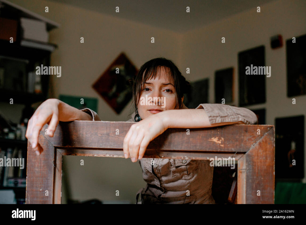 Portrait d'une femme peintre dans son atelier s'appuyant sur photo frame Banque D'Images