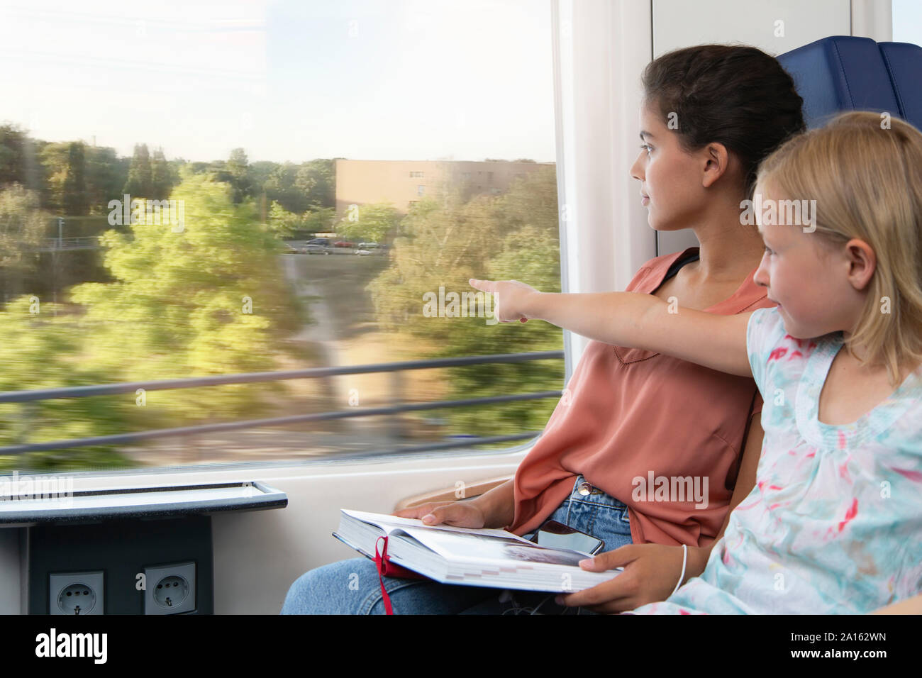 Deux soeurs assis dans un train, la lecture d'un livre Banque D'Images