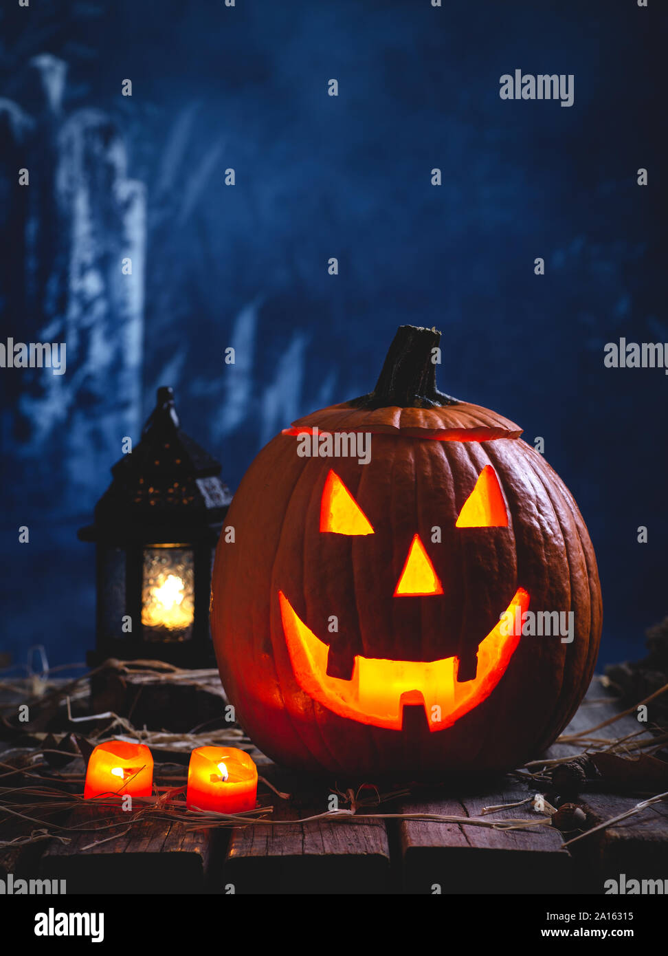 Glowing Jack-O-lanterne à brûler des bougies et des lanternes sur un arrière-plan foncé spooky Banque D'Images