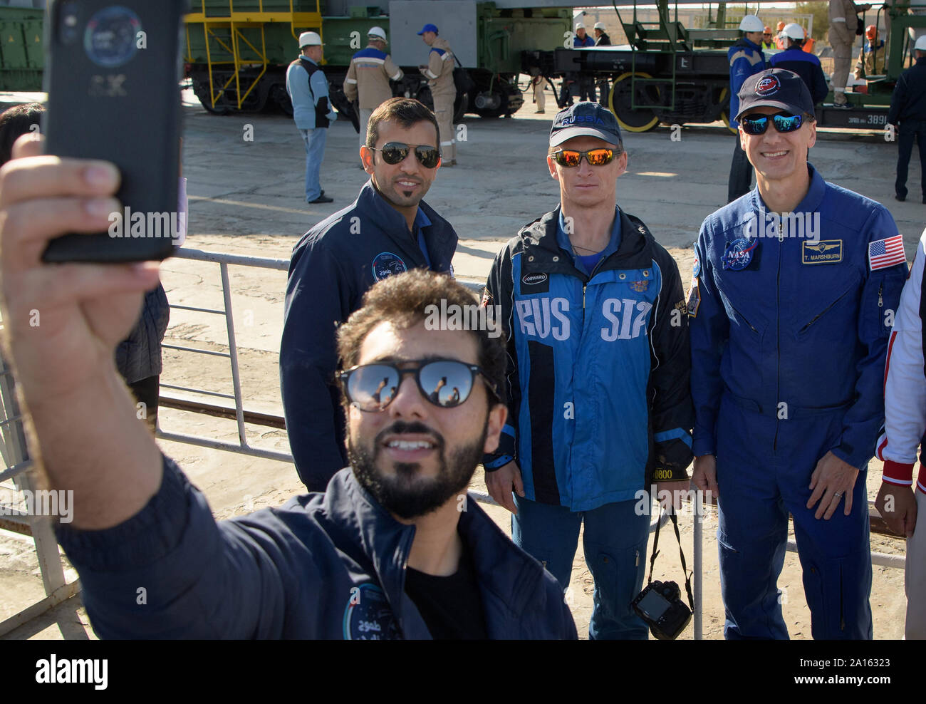 Un invité prend une sauvegarde avec selfies spaceflight participant Al-Neyadi Sultan des Emirats Arabes Unis, à gauche, et de l'expédition 61 de l'équipe de sauvegarde-membres Sergei Ryzhikov de Roskosmos et Thomas Marshburn de la NASA, de droite, comme la fusée Soyouz est mis en place par le train jusqu'à la rampe de lancement le 23 septembre 2019, au cosmodrome de Baïkonour au Kazakhstan. Les membres de l'équipage Expédition 61-Jessica Meir de la NASA et Oleg Skripochka de Roscosmos, vols habités et Ali Almansoori Hazzaa participant des Émirats arabes unis va lancer le 25 septembre sur l'engin spatial MS-15 Soyouz depuis le cosmodrome de Baïkonour à l'Intern Banque D'Images