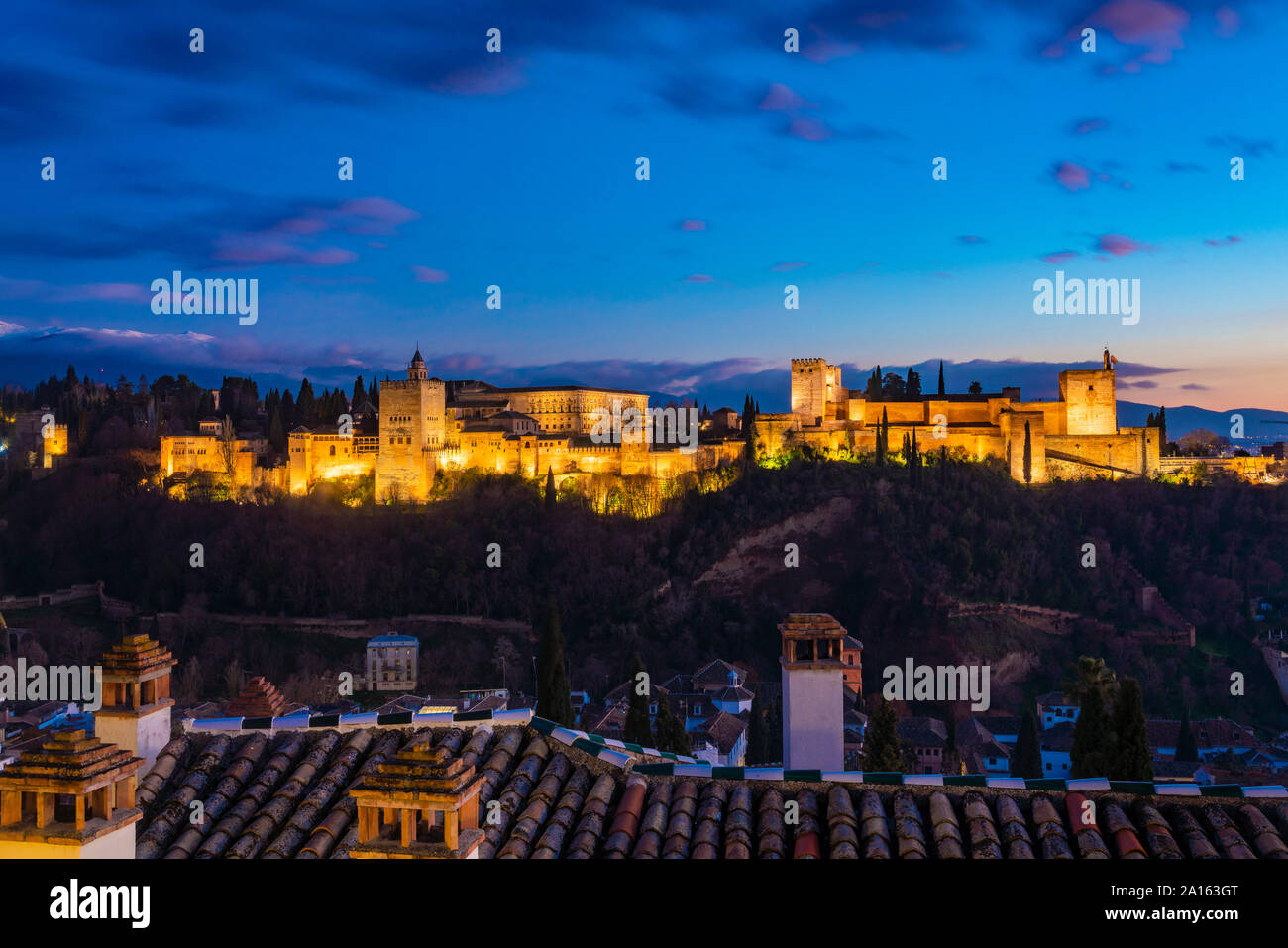 Vue de l'Alhambra avec la Sierra Nevada en arrière-plan au coucher du soleil, Granada, Espagne Banque D'Images