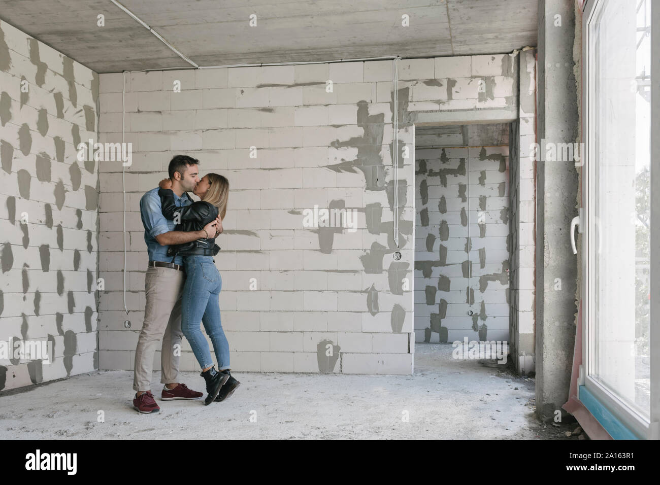 Heureux couple de futurs propriétaires at construction site Banque D'Images