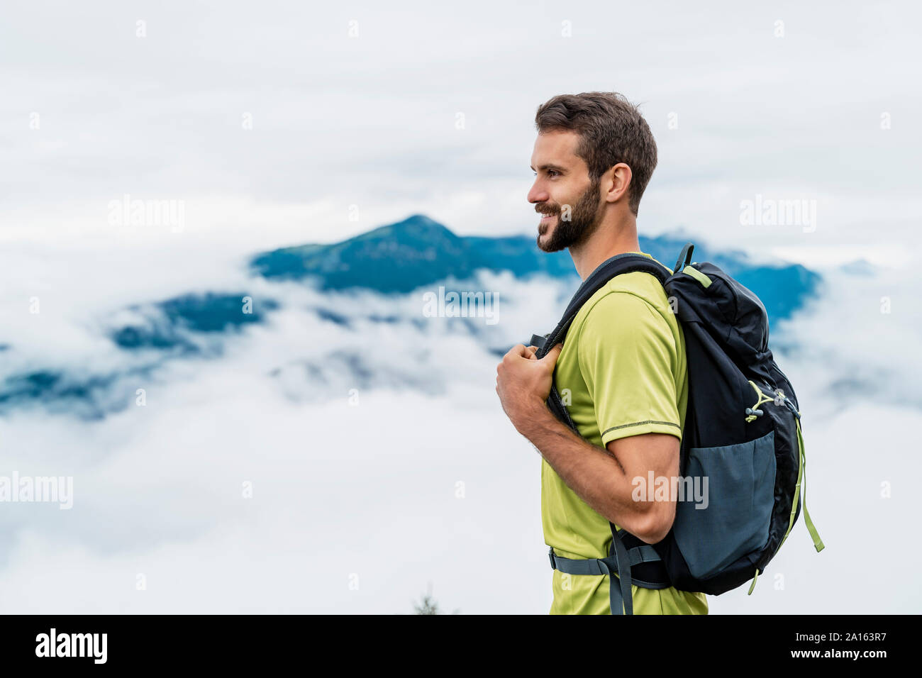 Smiling young man en randonnée dans les montagnes à la recherche à vue, Italia, Bavière, Allemagne Banque D'Images