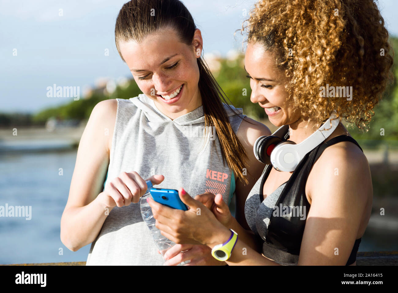 Deux jeunes femmes sportive heureux contrôle cell phone Banque D'Images