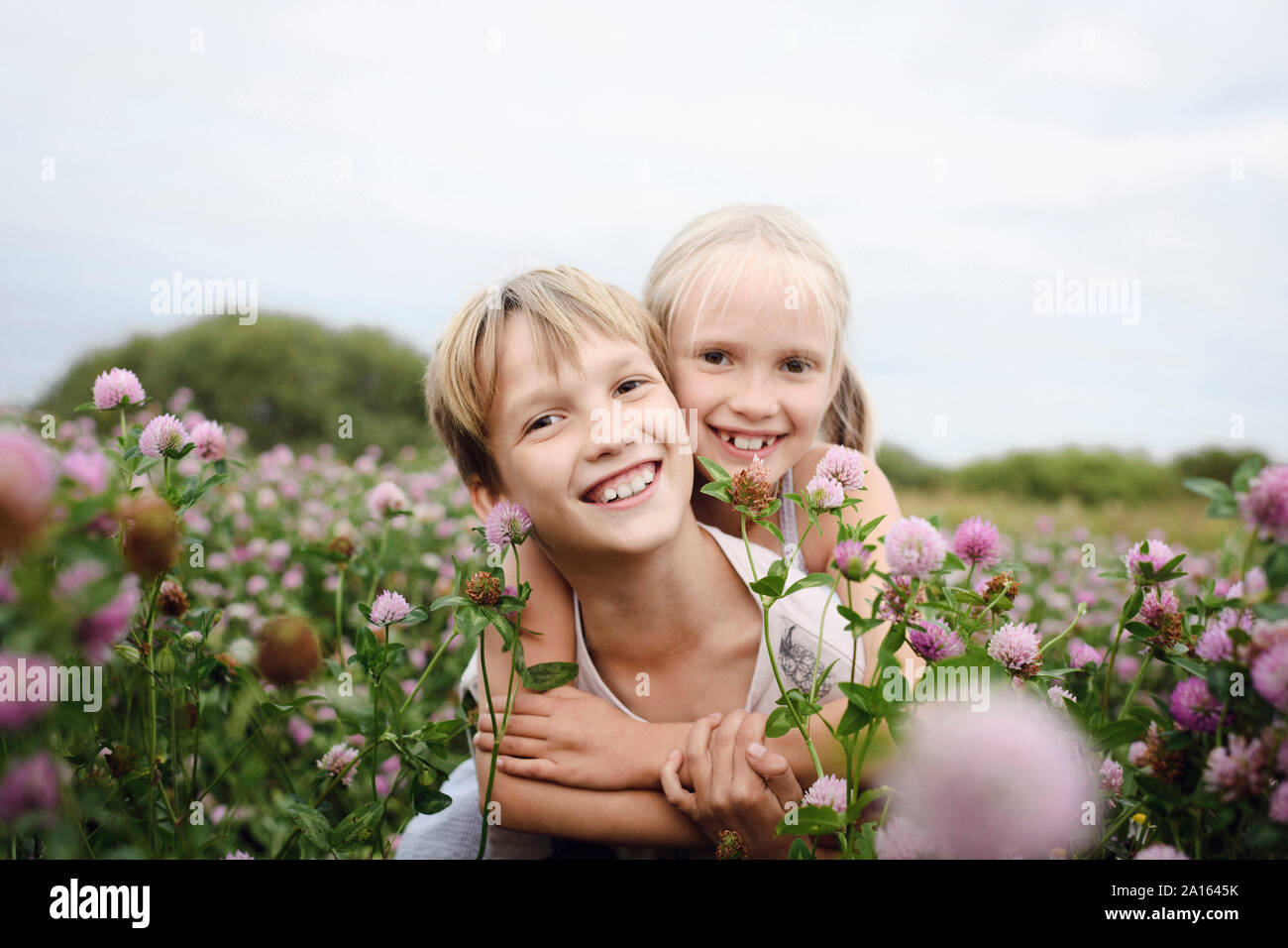Deux enfants souriants sur champ de trèfle Banque D'Images
