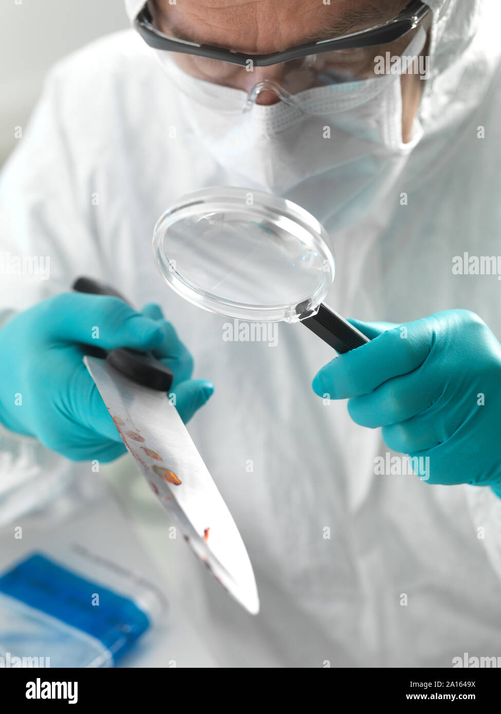 Médecin légiste examinant un couteau tiré d'une scène de crime avec violence dans le laboratoire Banque D'Images