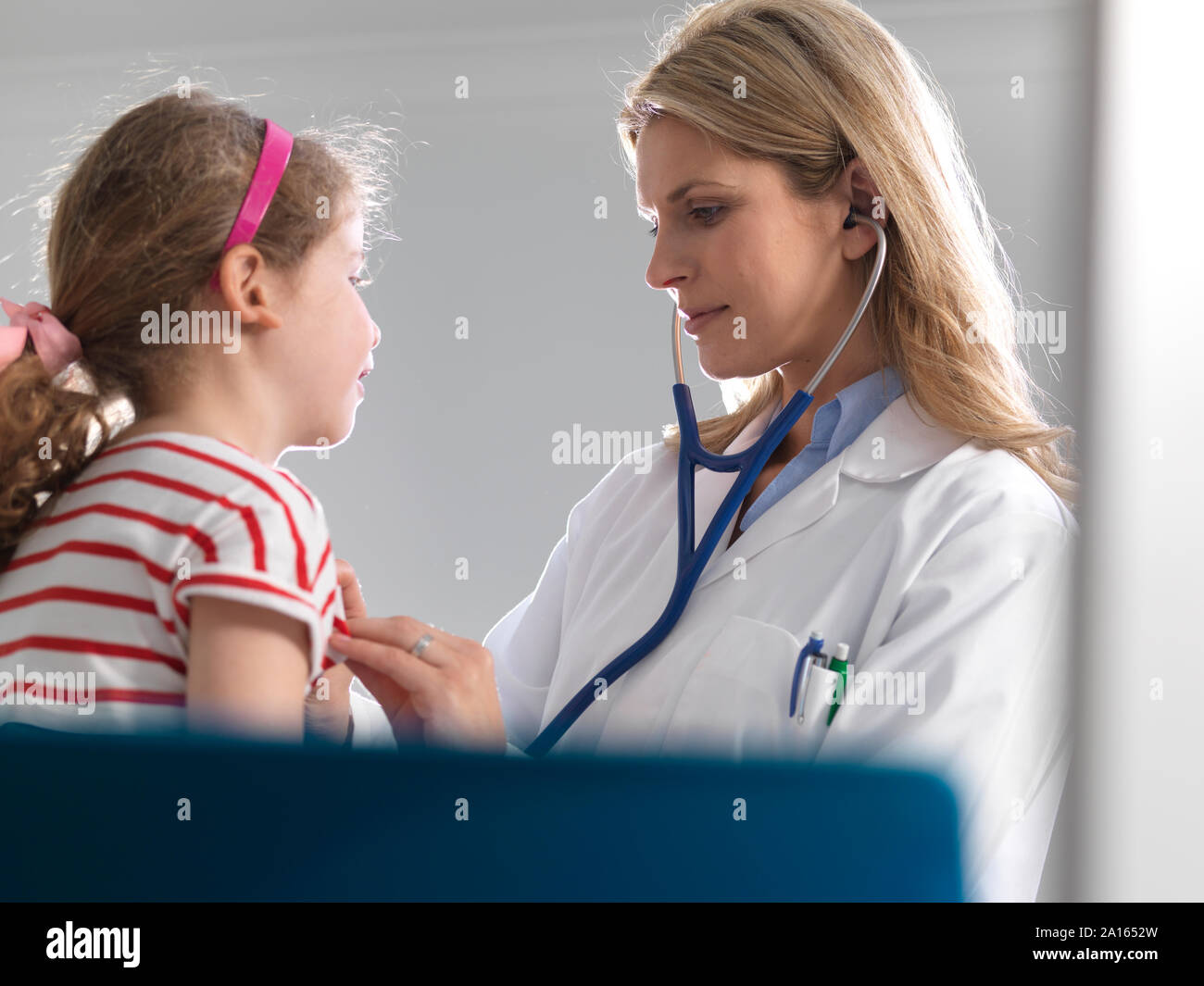 Femme médecin l'écoute d'une jeune fille coeur à l'aide d'un stéthoscope dans une clinique Banque D'Images