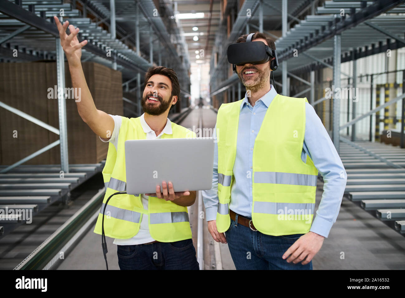 Homme avec portable et businessman wearing glasses VR en usine Banque D'Images