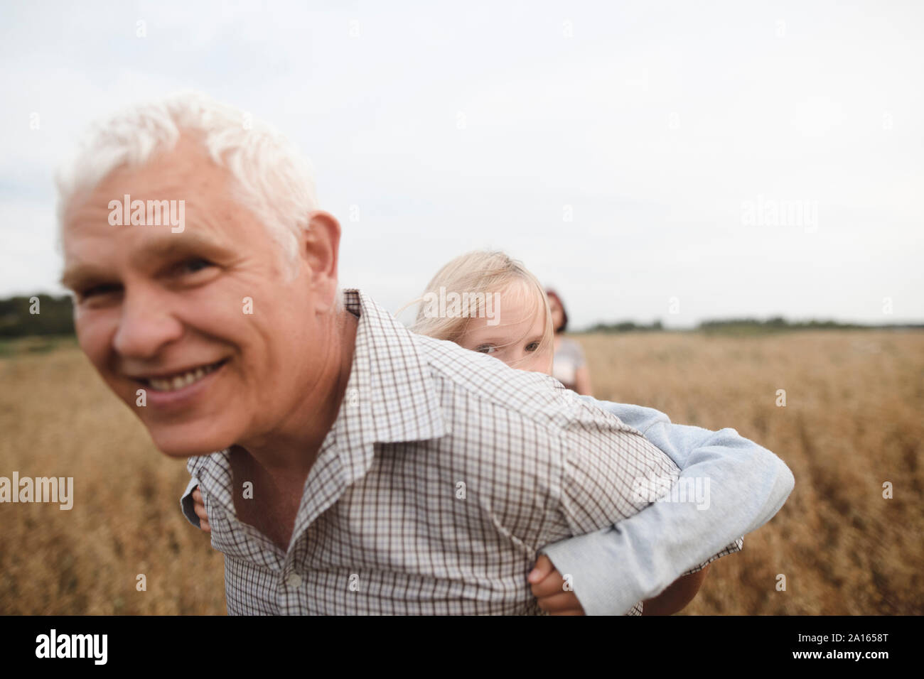 Grand-père donnant sa petite-fille un piggyback ride Banque D'Images