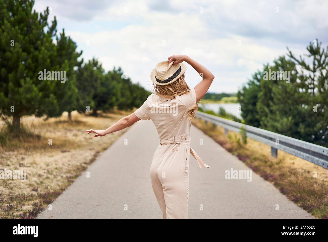 Rear view of woman with hat sur une route rurale Banque D'Images Rear view of woman with hat sur une route rurale Banque D'Images