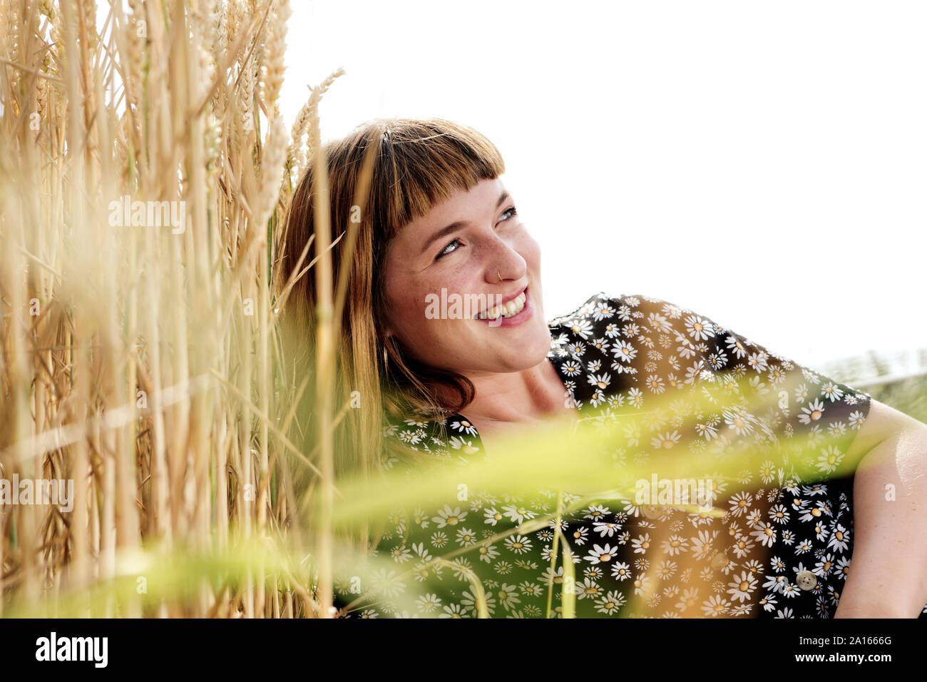 Portrait of smiling young woman wearing dress avec floral design dans la nature Banque D'Images