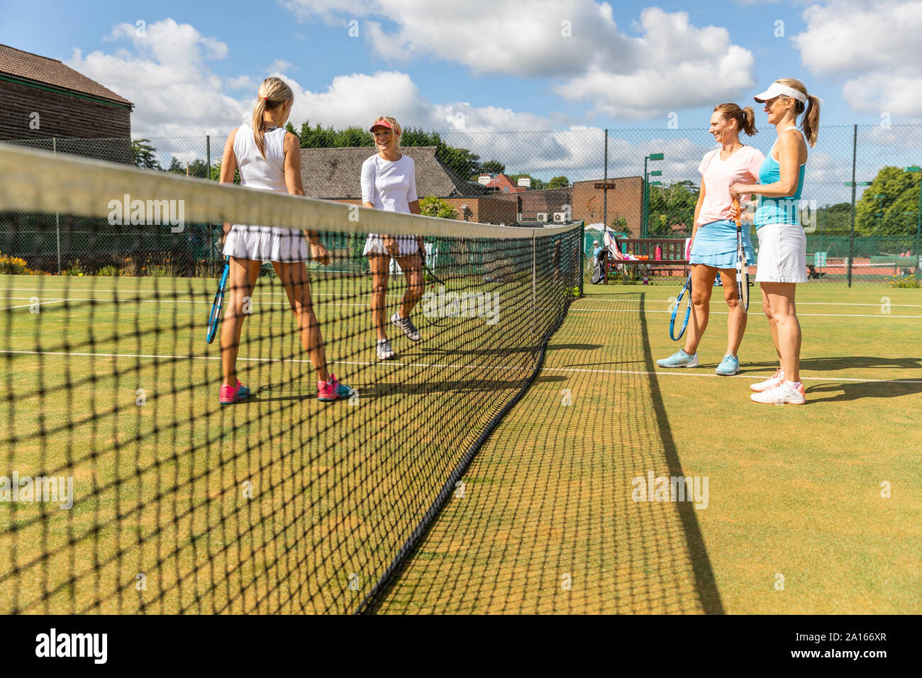 Les femmes mûres de parler sur l'herbe au cour tennis club Banque D'Images