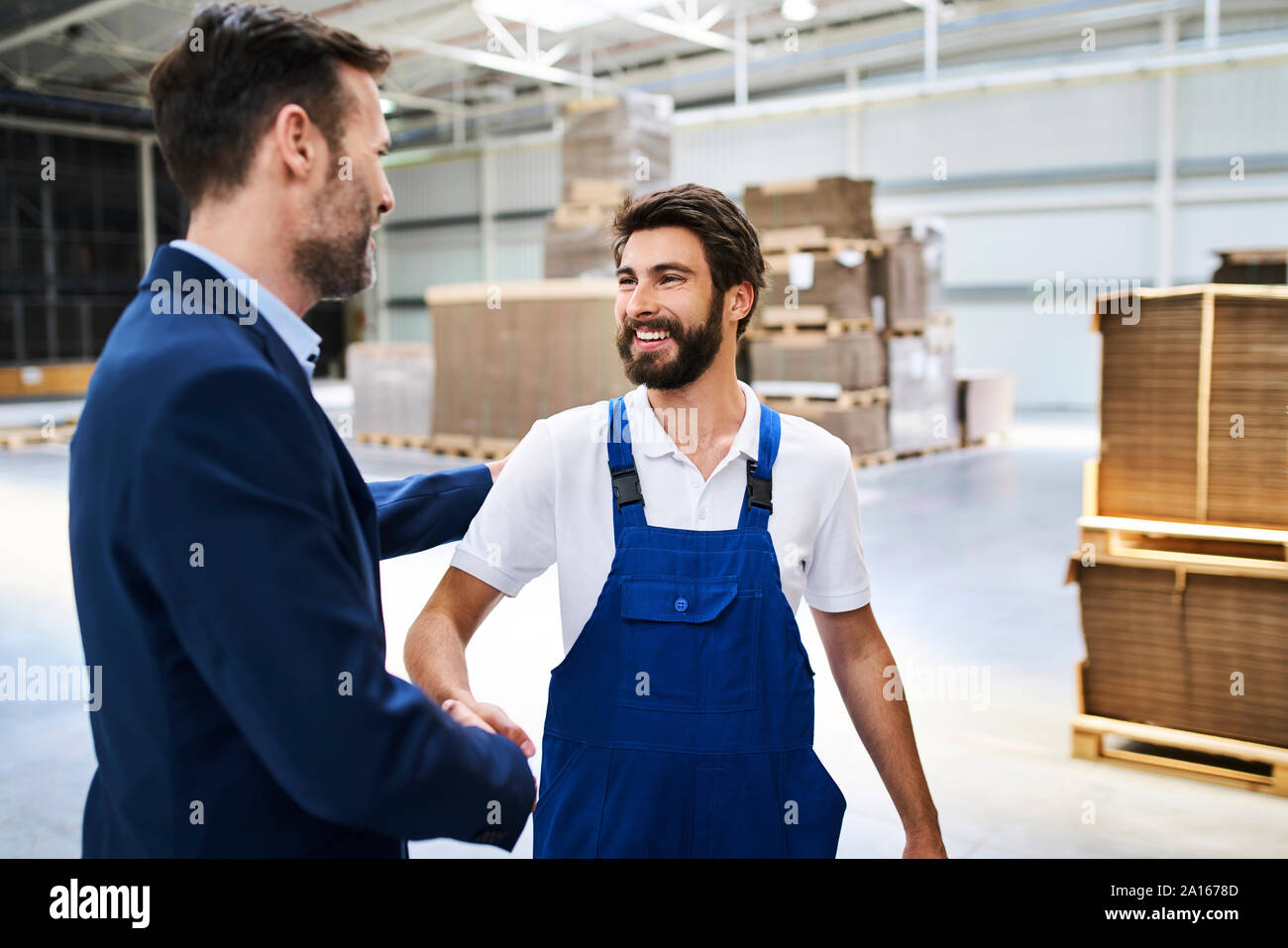Businessman shaking hands et dans une usine Banque D'Images
