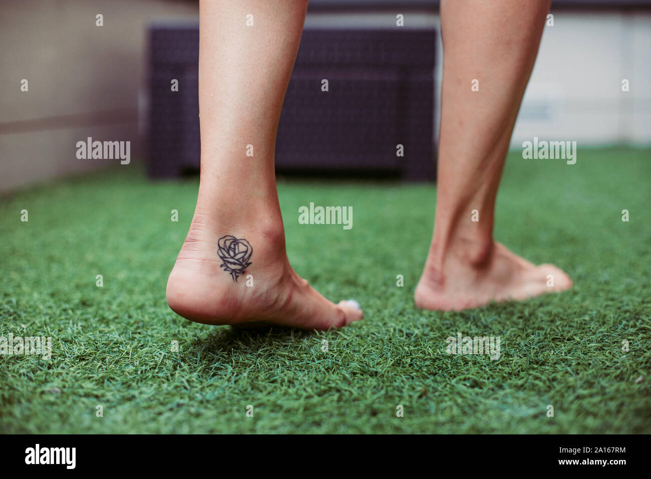 Close-up of a woman's marche pied tatoué sur le gazon artificiel Banque D'Images