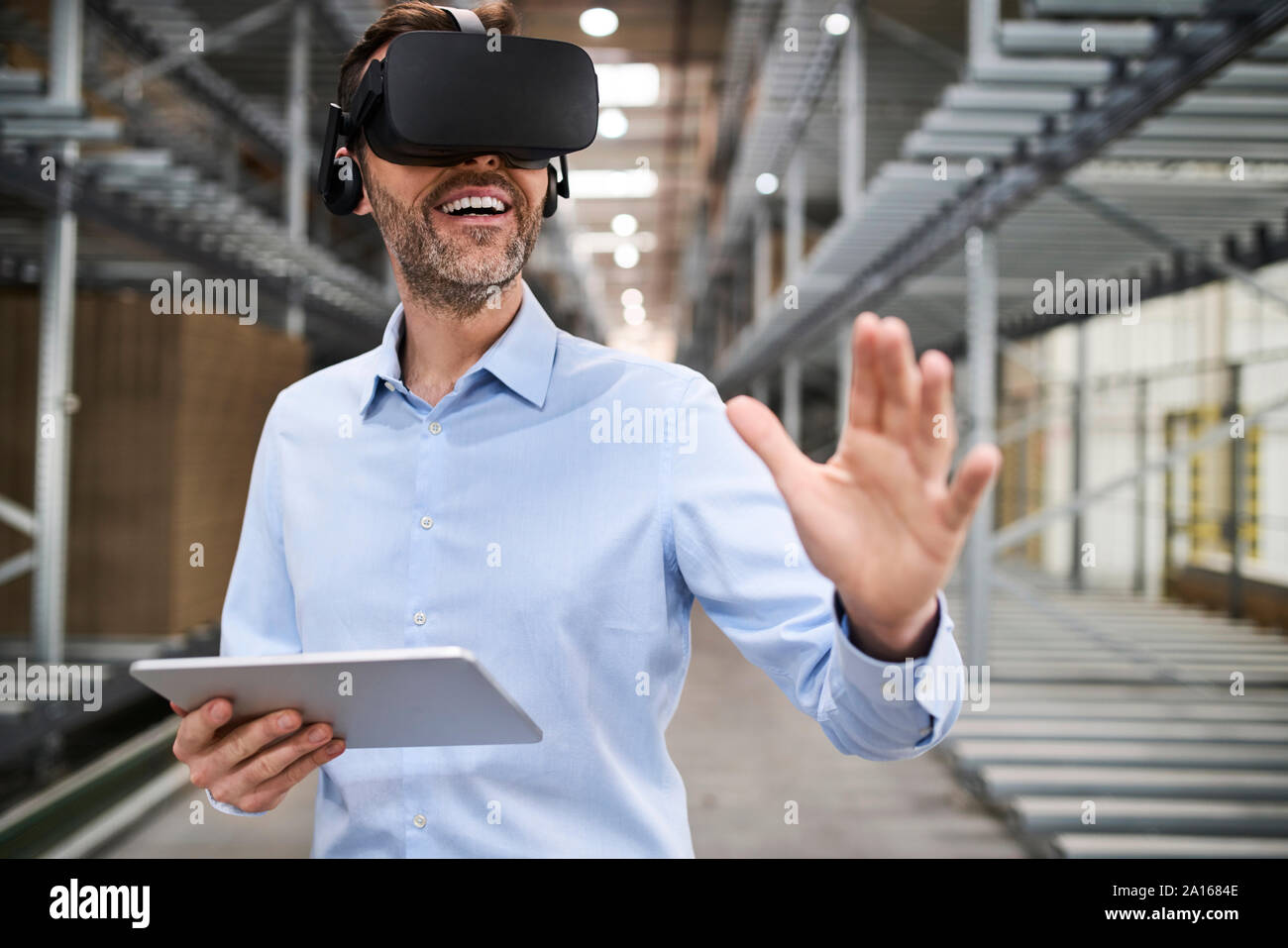 Businessman with tablet portant des lunettes VR en usine Banque D'Images