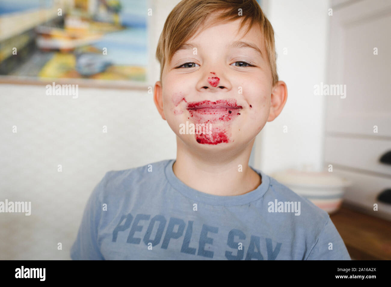 Portrait de jeune garçon souriant avec de la confiture de bleuets dans son visage Banque D'Images