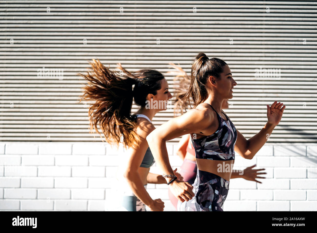 Trois jeunes femmes en marche sportive dans la ville Banque D'Images
