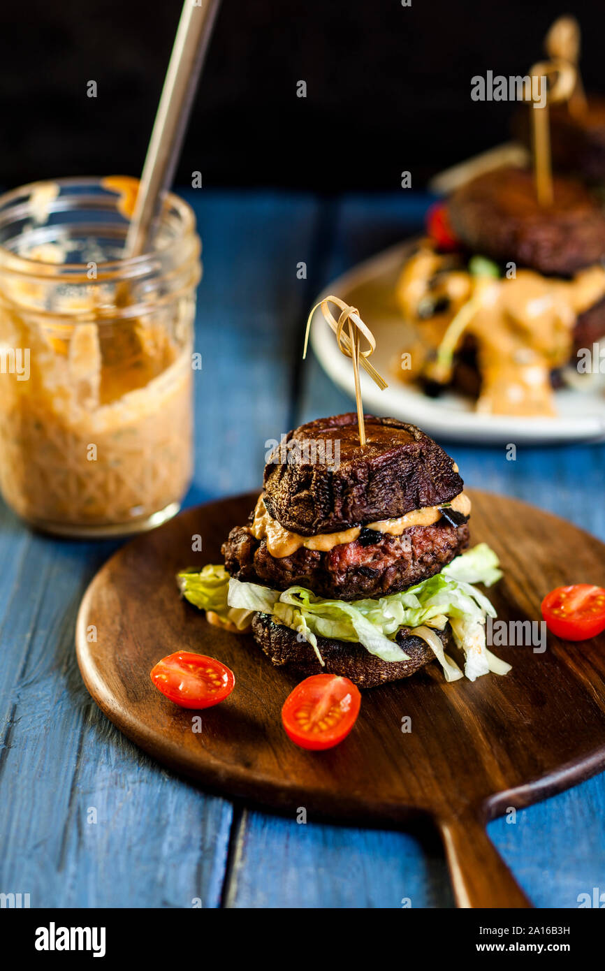 Close-up of fresh burger sur plateau de service par-dessus de la table jar Banque D'Images Close-up of fresh burger sur plateau de service par-dessus de la table jar Banque D'Images
