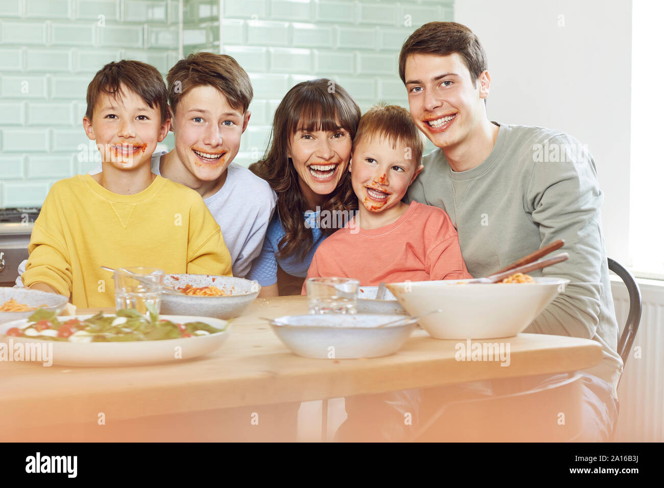 Portrait de mère et fils pour le déjeuner, avec des visages plein de sauce tomate Banque D'Images