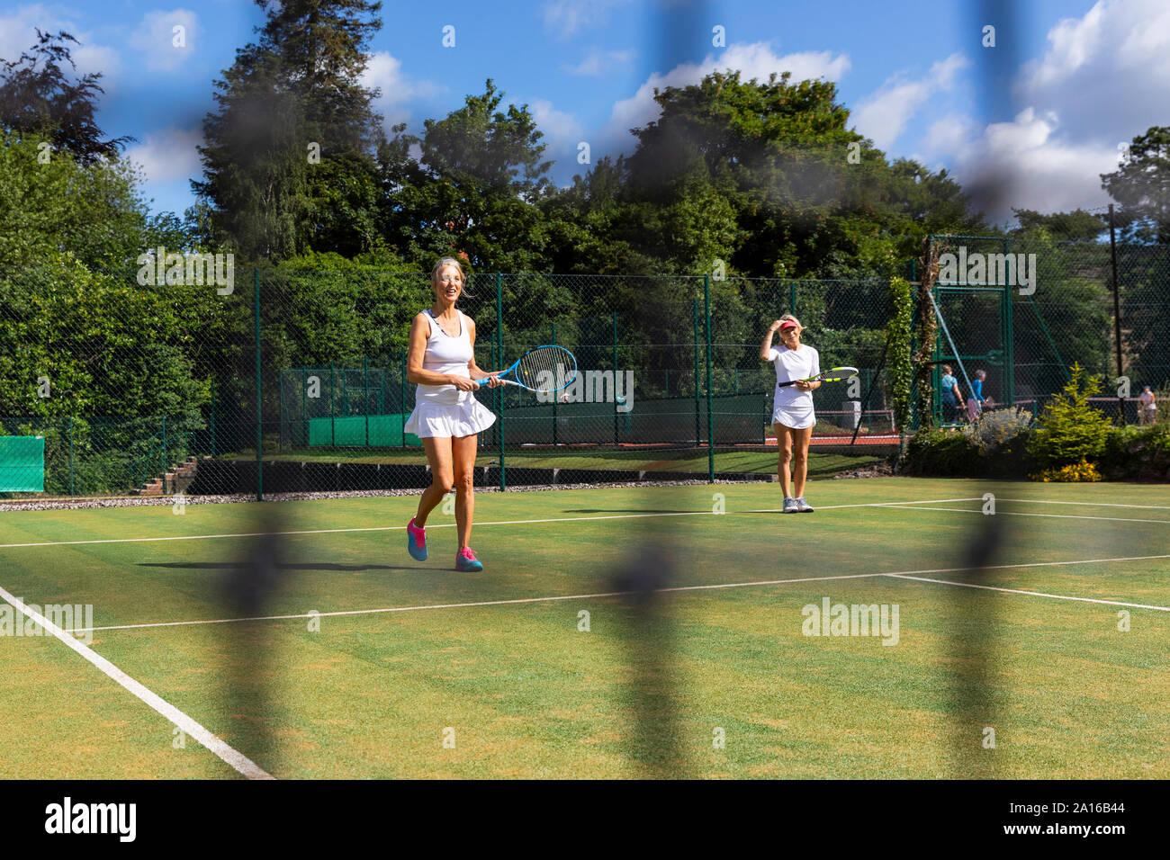 Les femmes mûres pendant un match de tennis sur gazon Banque D'Images