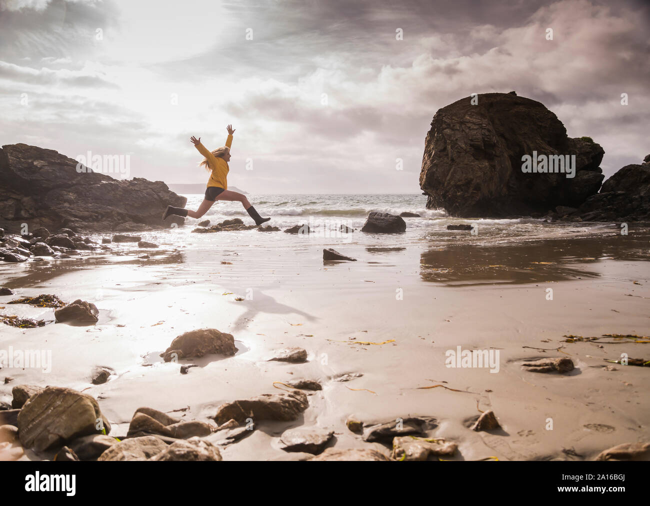 Femme sautant sur la plage Banque D'Images