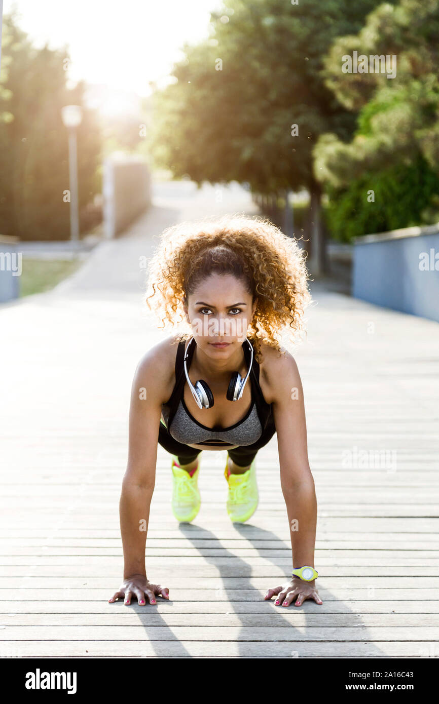 Sporty woman doing push-ups sur un pont Banque D'Images