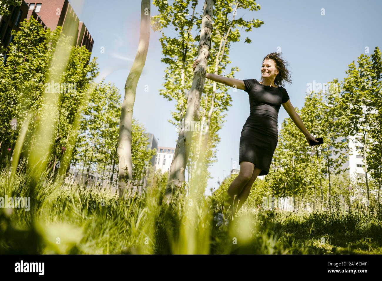 Femme mature avec smartphone ayant une pause dans la nature Banque D'Images