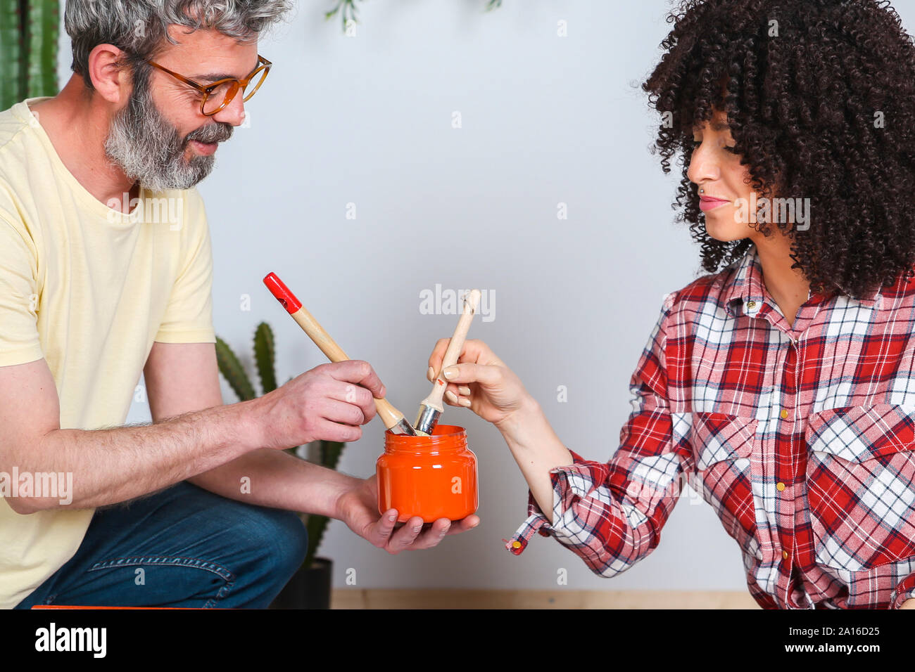 Couple à l'aide de pinceaux et de la peinture à la maison Banque D'Images