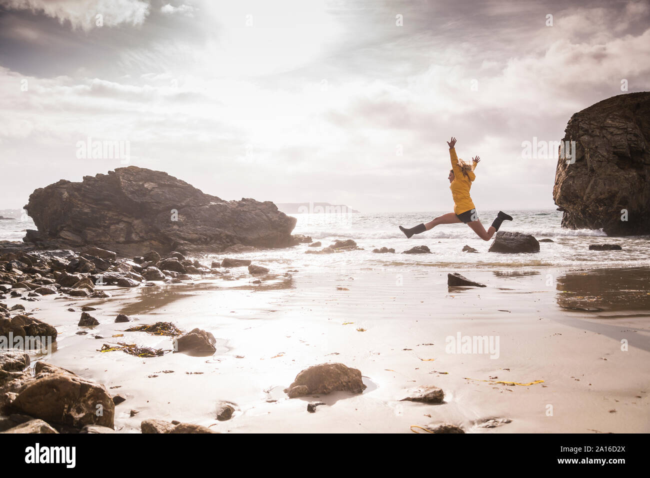 Femme sautant sur la plage Banque D'Images