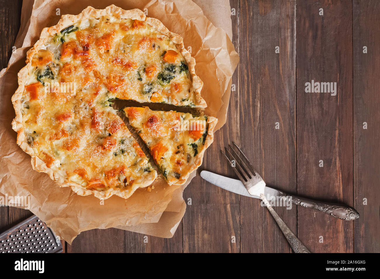 Quiche maison tarte ou avec des légumes, épinards et fromage sur la table en bois rustique Banque D'Images