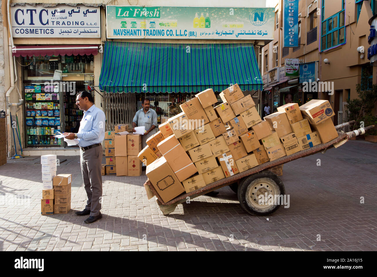 Dubaï - un commerçant offre un panier avec des boîtes dans un magasin situé dans le souk. Banque D'Images