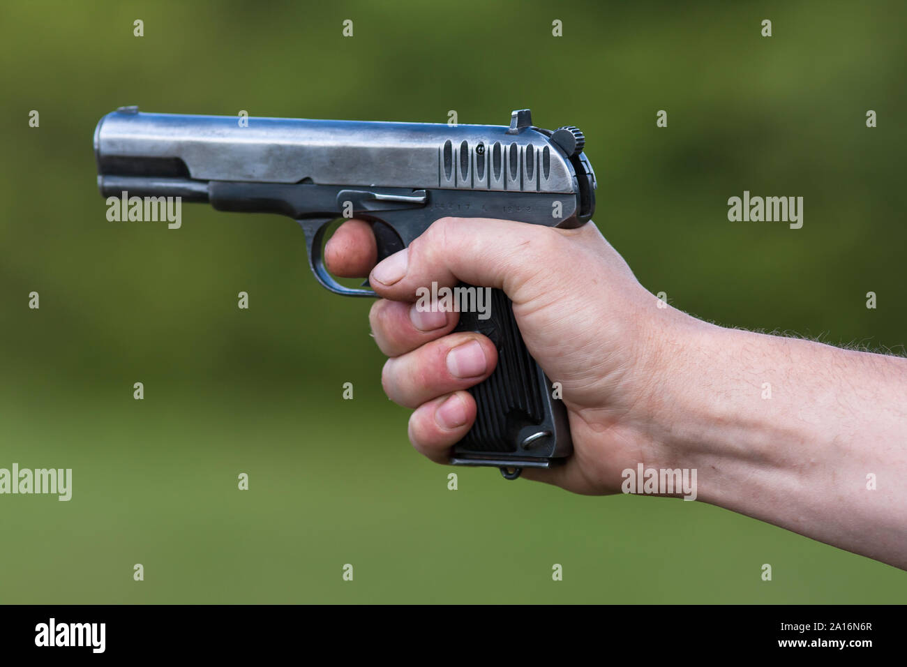 TT le pistolet en main sur l'arrière-plan flou Banque D'Images