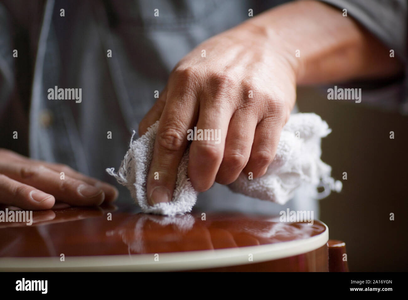 Mains d'un homme un essuyage de la surface vernie. Banque D'Images