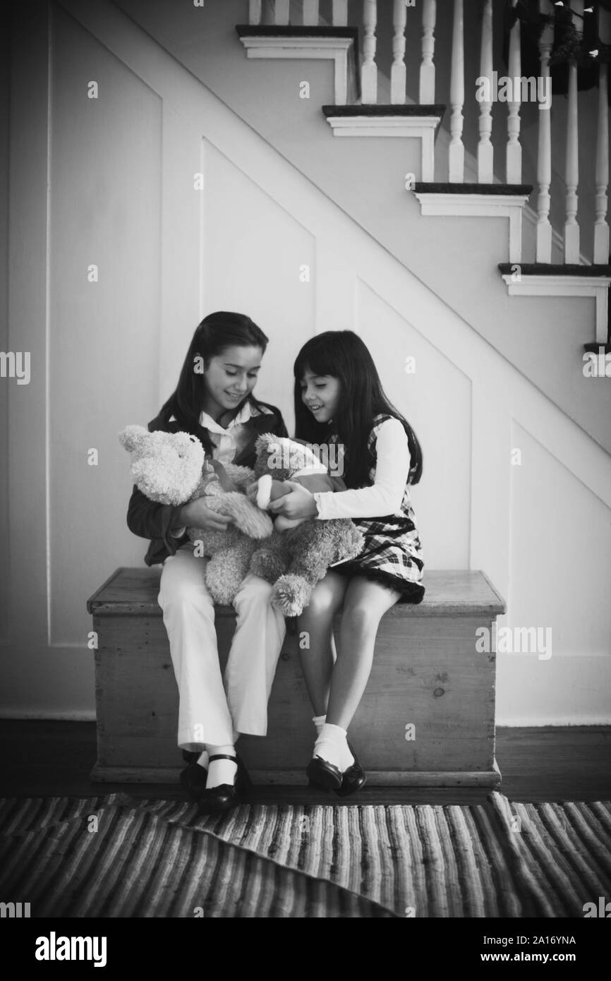 Vue de face de deux petites filles jouant avec des jouets en peluche. Banque D'Images