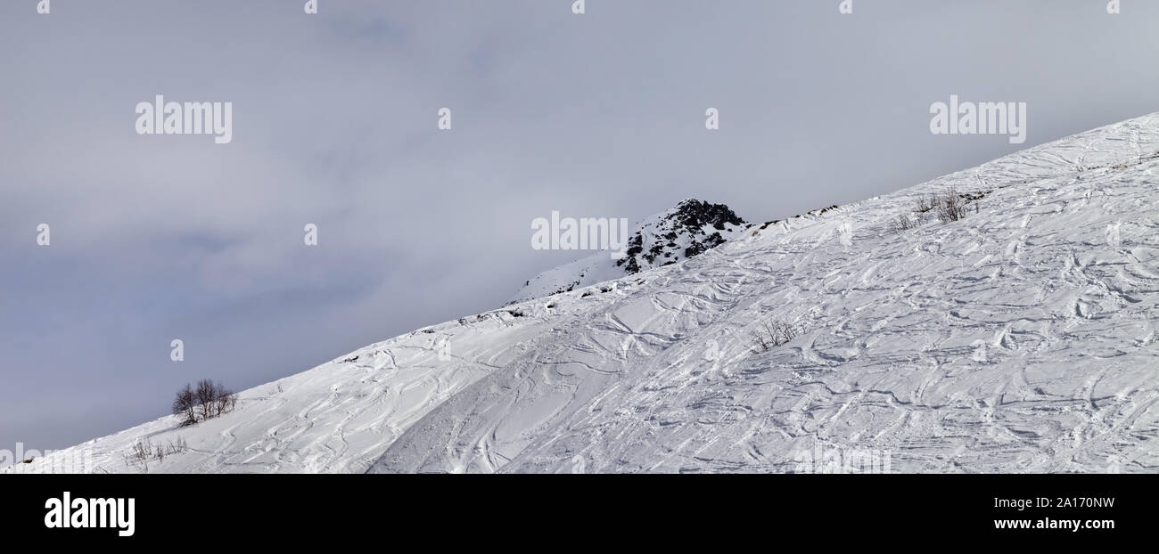 Vue panoramique sur la pente de neige en hors-piste, avec des pistes de skis et snowboards en gris journée d'hiver. Montagnes du Caucase, région de Svaneti, Tetnuldi Georg Banque D'Images