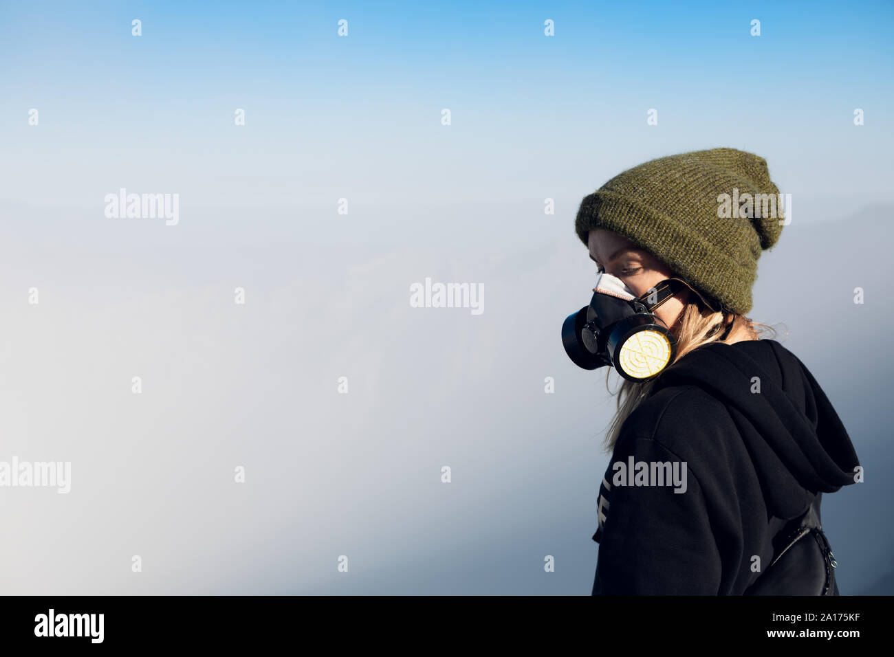Femme au masque à filtre pour protéger le souffle de gaz toxiques et des vapeurs toxiques pendant la randonnée aventure volcan Kawah Ijen à avec cratère lac acide Banque D'Images