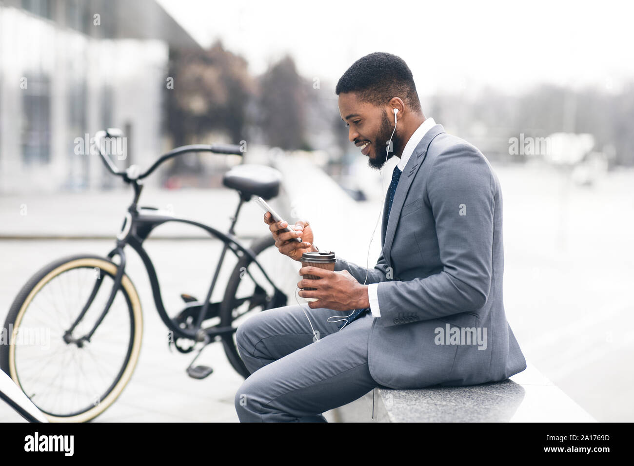 Beau afro businessman texting on phone pendant pause café Banque D'Images
