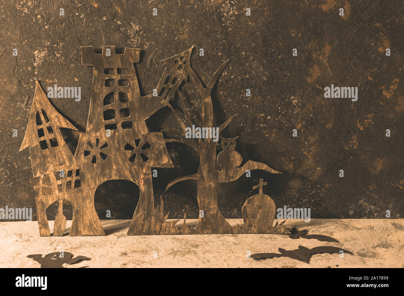 Maison de la sorcière avec une grave et un arbre effrayant taillée dans le papier noir sur un mur de béton. copier l'espace. De l'artisanat pour l'halloween concept. Couture Banque D'Images