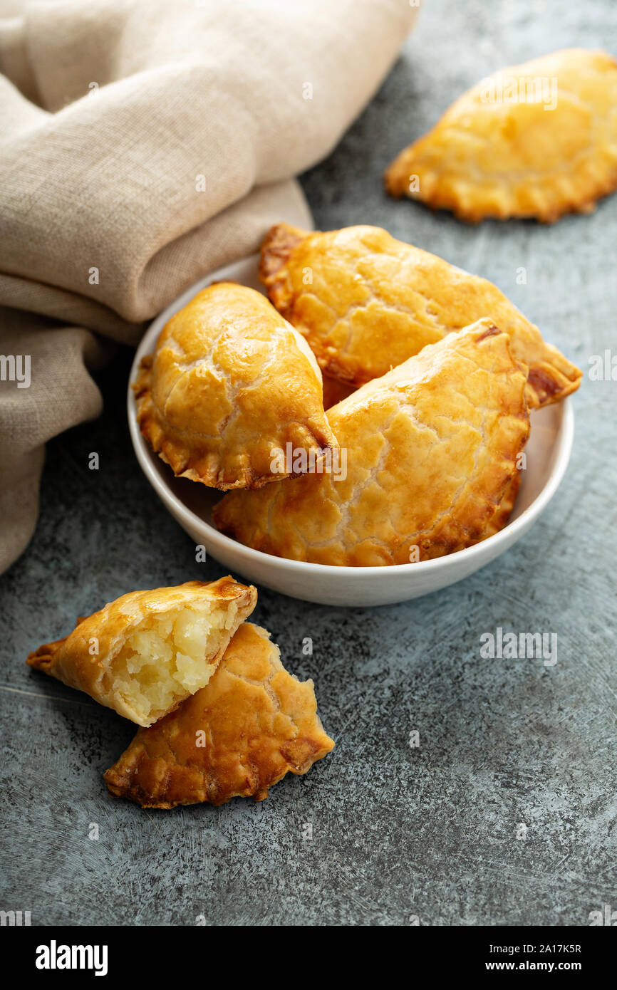 Part des tartes, pasties, samosas ou pierogies avec remplissage de pommes de terre au four d'or Banque D'Images