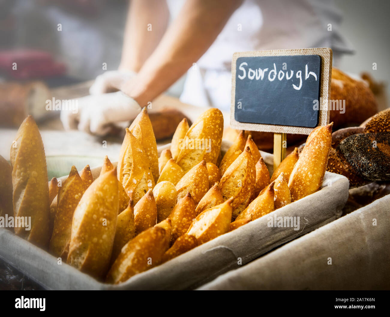 Baguettes de pain au levain avec le chef travailler en arrière-plan Banque D'Images