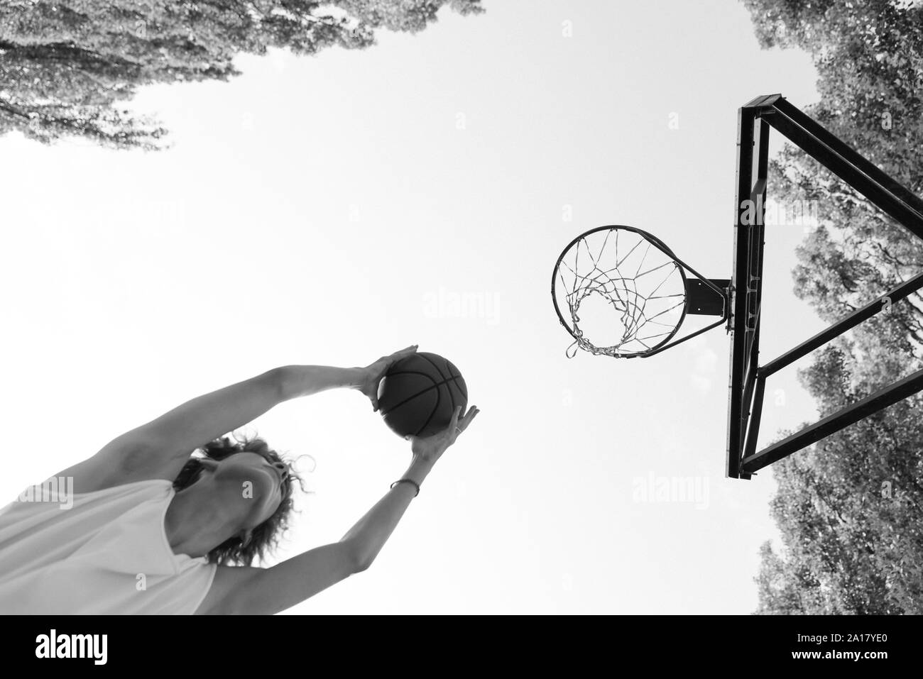 Un jeune joueur de basket-ball en conduisant à l'hoop avec quelques coups de fantaisie. Banque D'Images