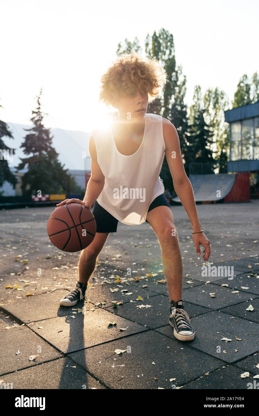 Les hommes avec des cheveux tout en courbes, jouer au basket-ball sur une rue, bien fraire Banque D'Images