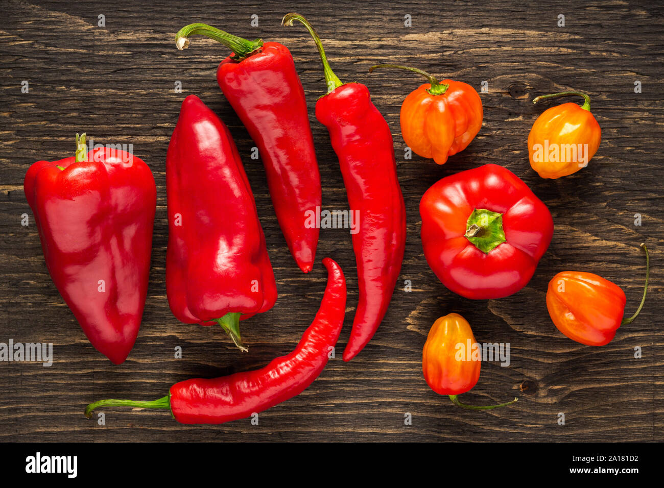 Assortiment de poivrons frais sur un fond de bois foncé texturé Banque D'Images