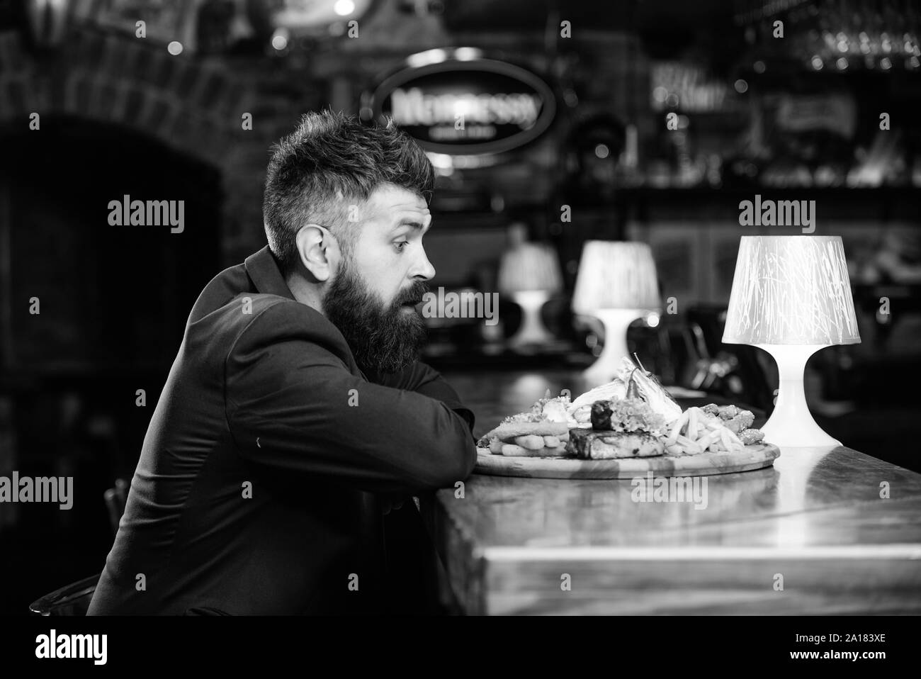 Des calories. Vous pourrez vous détendre après une dure journée de travail. Woman costume formel s'asseoir à comptoir bar. L'homme a reçu de pommes de terre frites repas avec viande et poisson, lavash. Profitez de repas. Il méritent de délicieux repas. Banque D'Images
