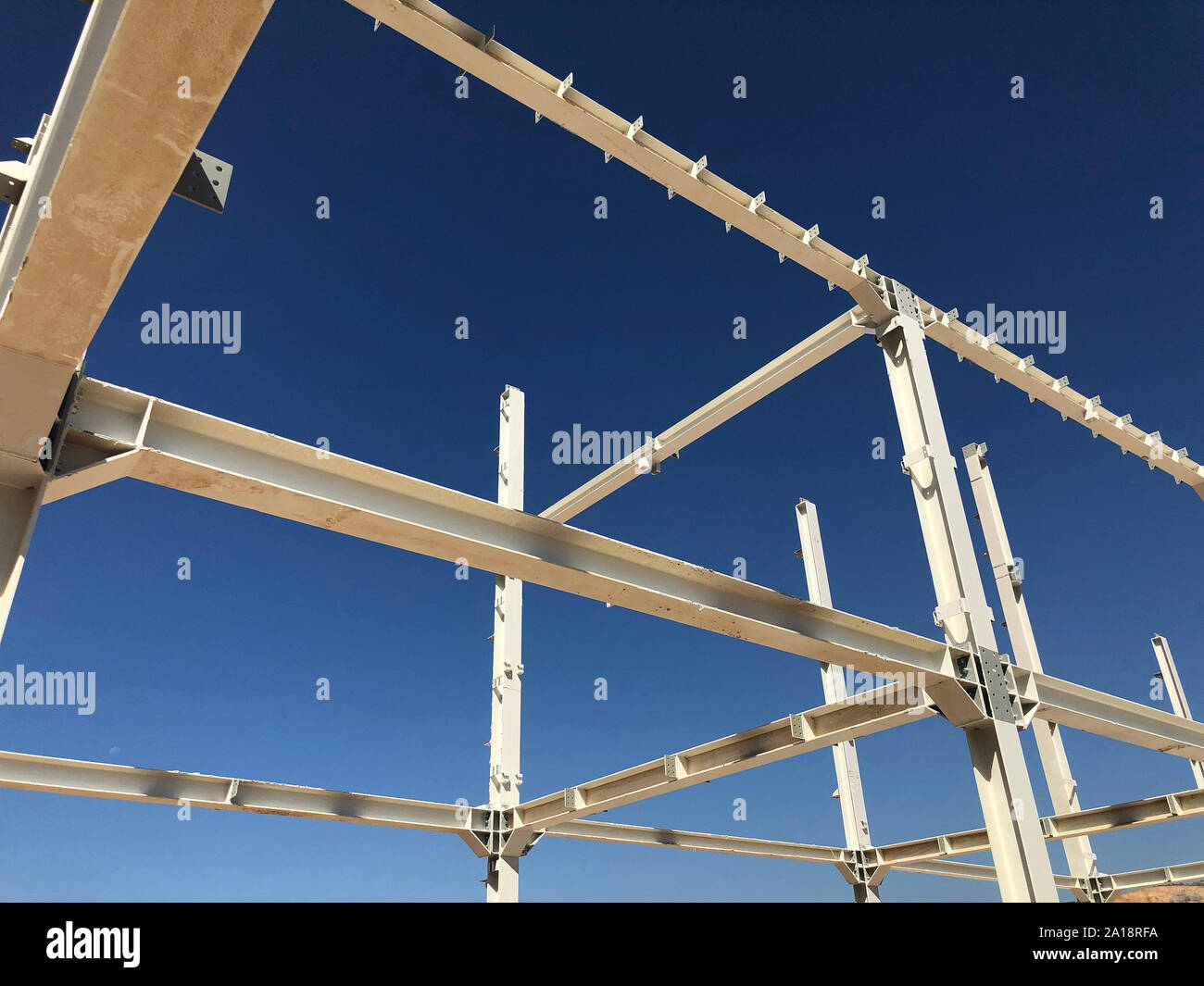 Cadre métallique de bâtiment industriel. Piliers et poutres en face de ciel bleu clair. Banque D'Images
