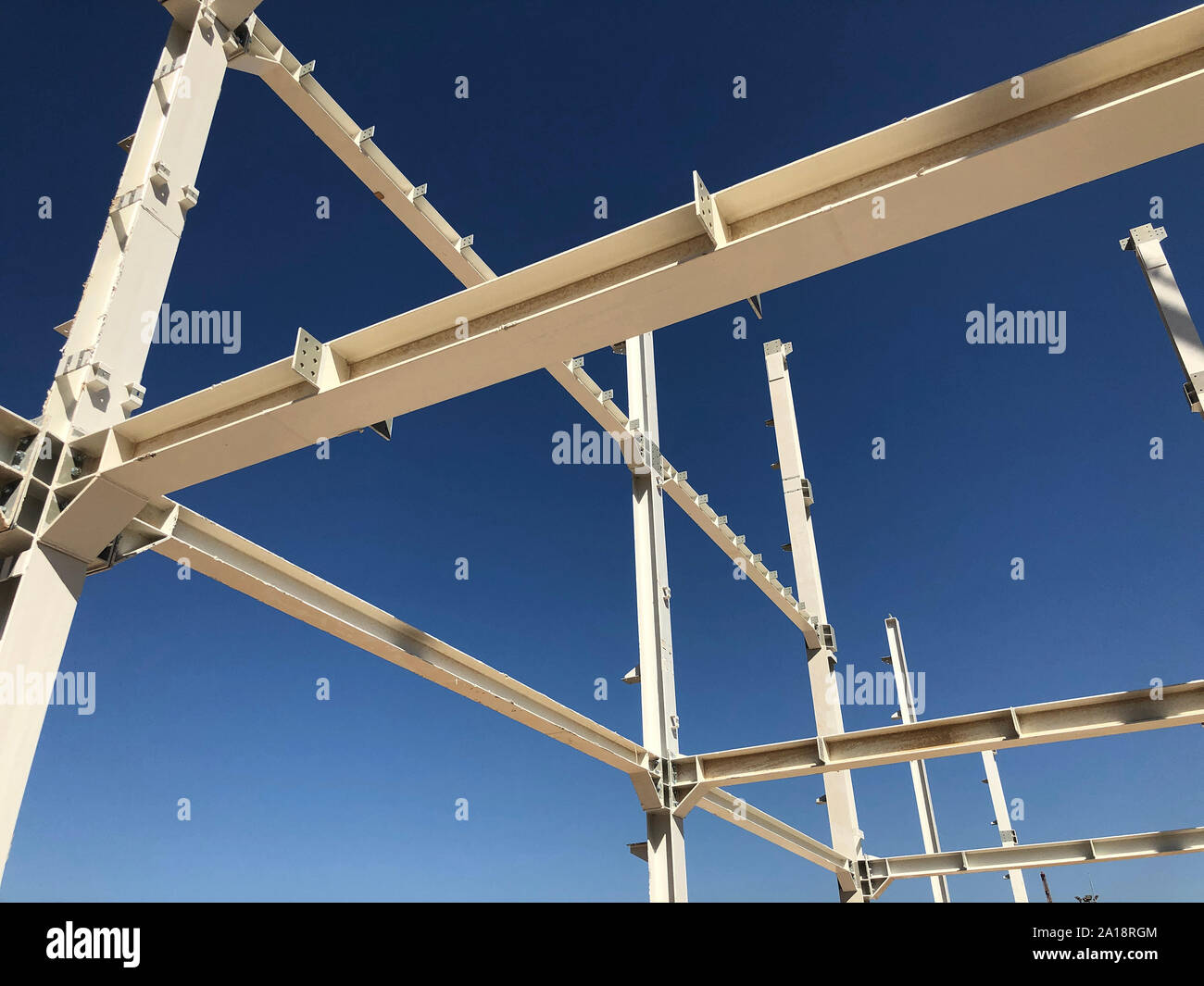 Cadre métallique de bâtiment industriel. Piliers et poutres en face de ciel bleu clair. Banque D'Images