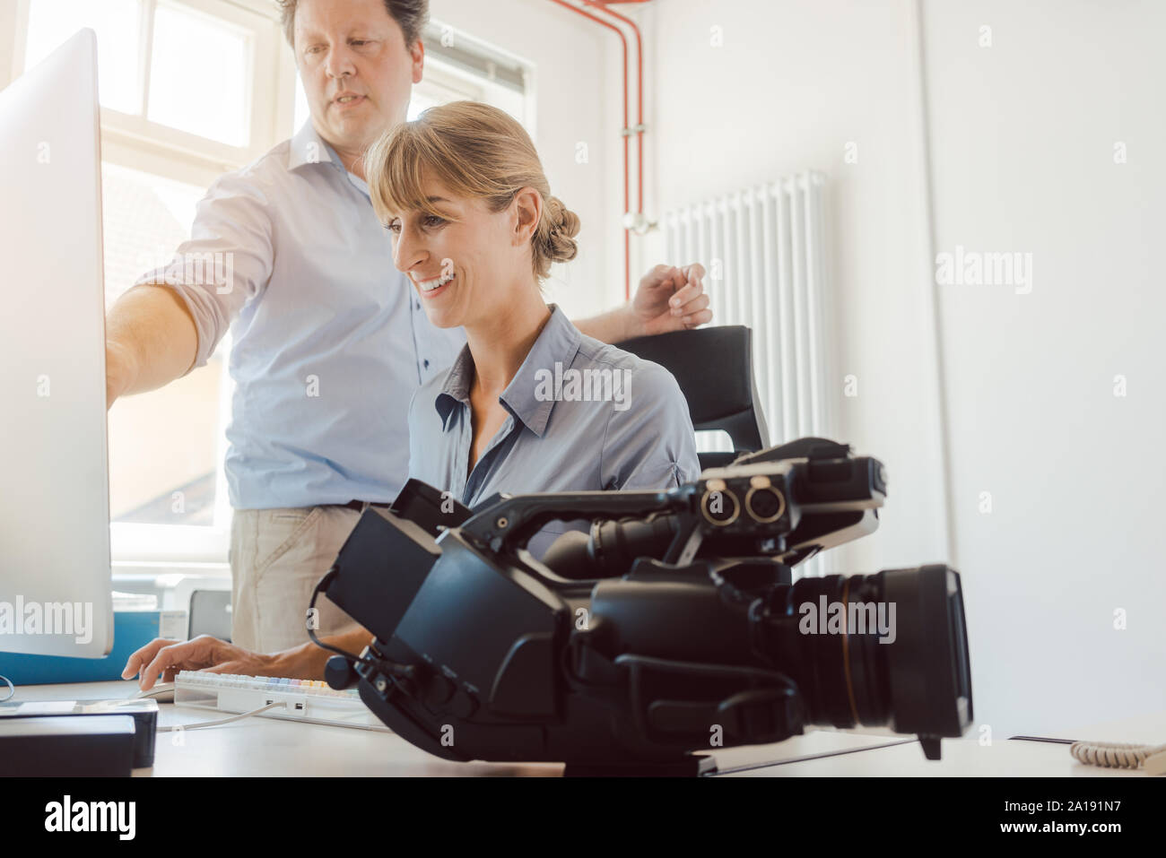La femme et l'homme travaillant sur une vidéo en post-production Banque D'Images