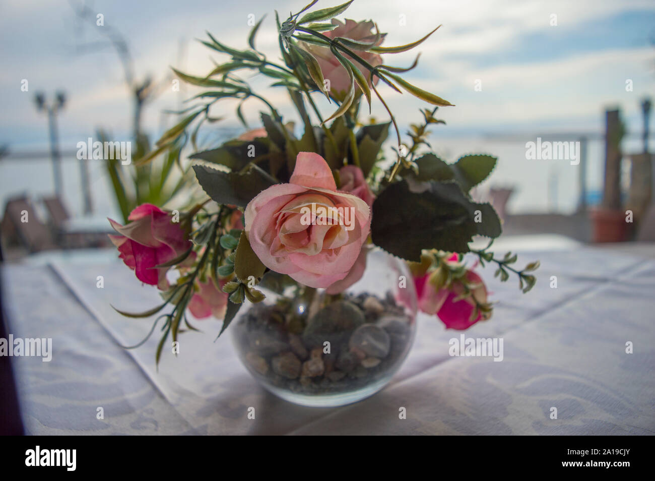 Bouquet de fleurs dans un vase en verre sur une table dans un restaurant. Banque D'Images