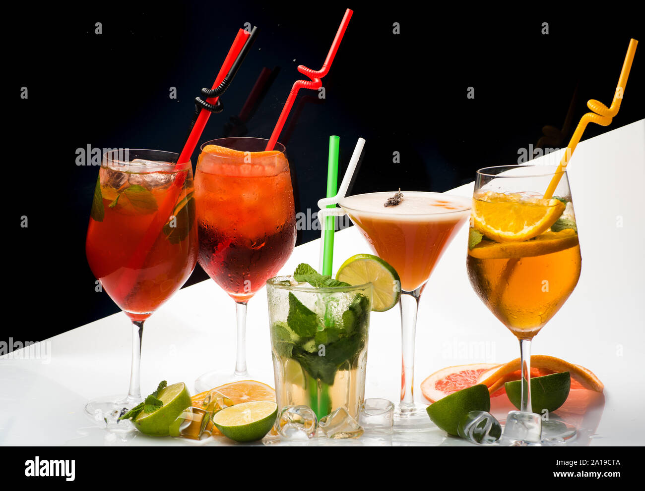 Des boissons alcoolisées et des fruits au restaurant. Coupe de fruits et verre à cocktail au bar. Parti et vacances d'été. Des cocktails sur fond noir et blanc Banque D'Images